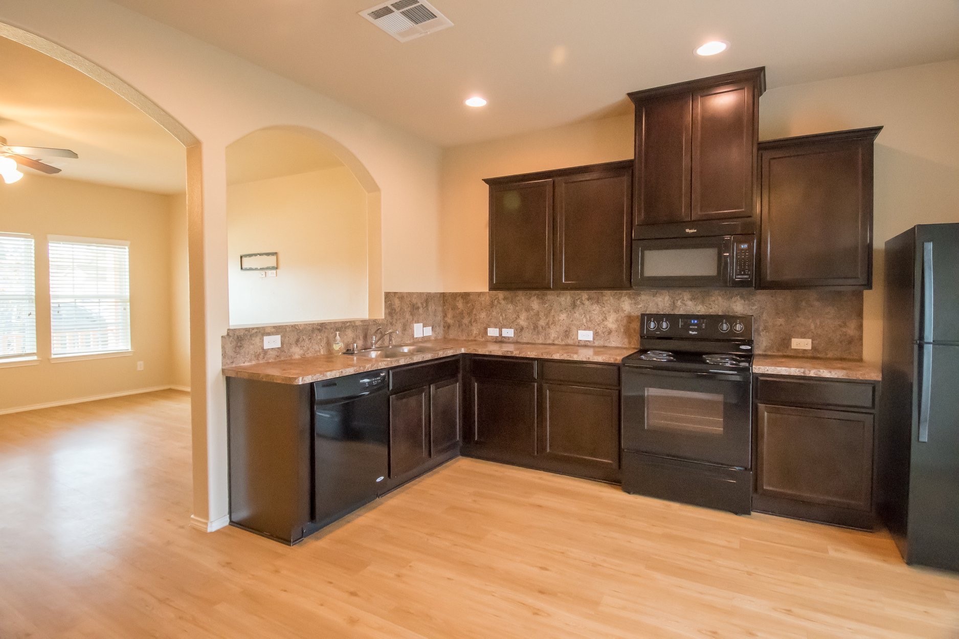 2602 Arica Lane Spring, TX 77373 - Photo 4 of 17 Bright, open room with light wood flooring and neutral walls. Features an arched doorway and a window allowing natural light. Perfect for a cozy living area or home office.