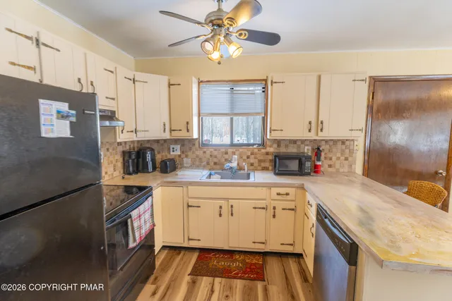 a kitchen with a sink dishwasher a stove and a refrigerator with wooden floor