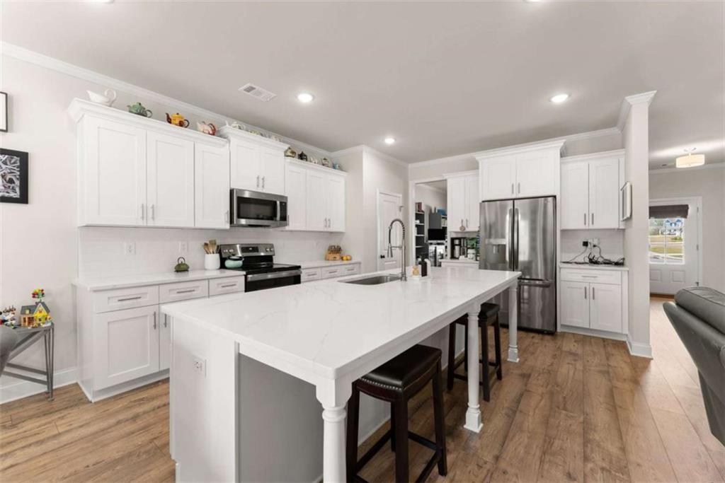 568 Dunagan Court Winder, GA 30680 - Photo 21 of 61 a kitchen with white cabinets and stainless steel appliances