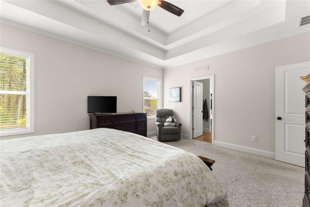568 Dunagan Court Winder, GA 30680 - Photo 27 of 61 a bedroom with a bed and a chandelier