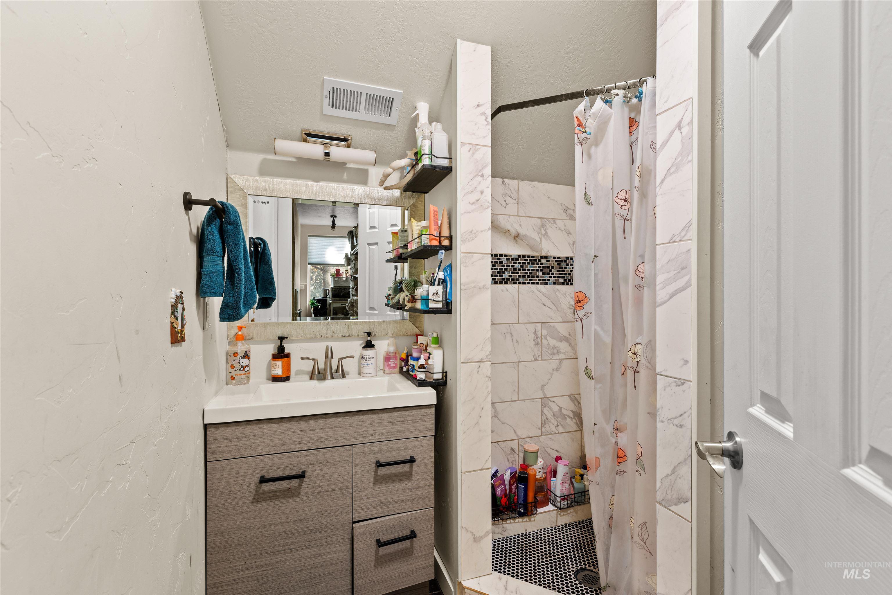 3488 Ward Road Cambridge, ID 83610 - Photo 32 of 50 Bathroom featuring vanity, a shower stall, a textured wall, and a textured ceiling