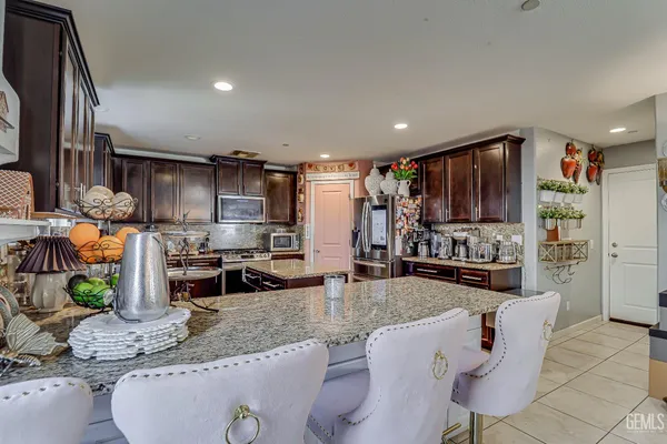 a kitchen with stainless steel appliances granite countertop a sink refrigerator and cabinets