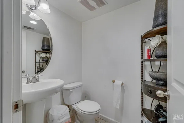 a bathroom with a toilet a sink and mirror