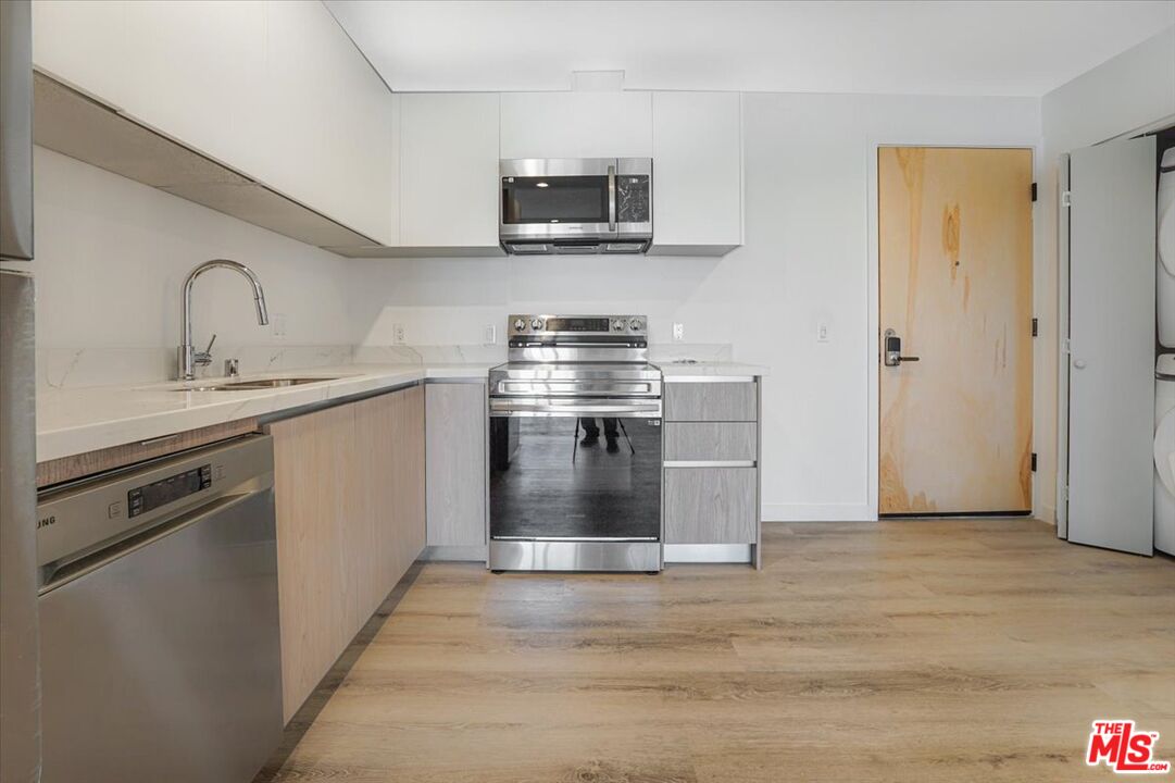 10918 Camarillo Street, Unit 103 North Hollywood, CA 91602 - Photo 11 of 38 a kitchen with stainless steel appliances granite countertop a stove and a sink