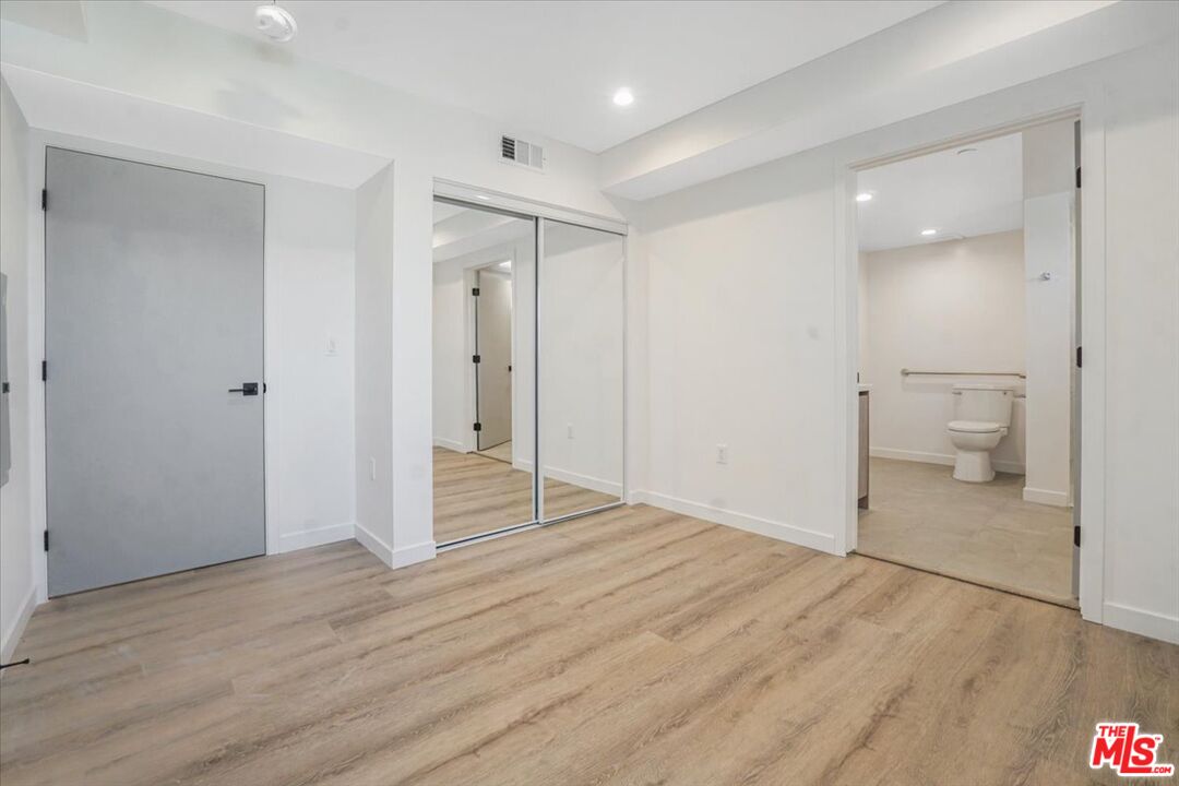 10918 Camarillo Street, Unit 103 North Hollywood, CA 91602 - Photo 19 of 38 a view of a room with wooden floor and a bathroom