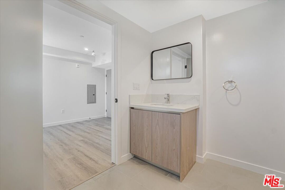 10918 Camarillo Street, Unit 103 North Hollywood, CA 91602 - Photo 22 of 38 a bathroom with a sink mirror and vanity