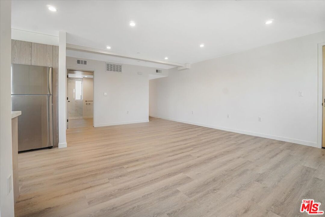 10918 Camarillo Street, Unit 103 North Hollywood, CA 91602 - Photo 30 of 38 an empty room with wooden floor and windows
