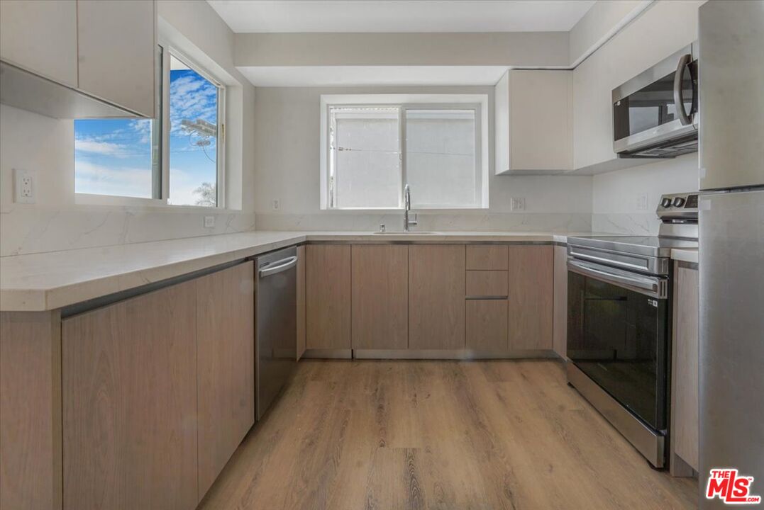 10918 Camarillo Street, Unit 103 North Hollywood, CA 91602 - Photo 31 of 38 a kitchen with a sink stove and cabinets