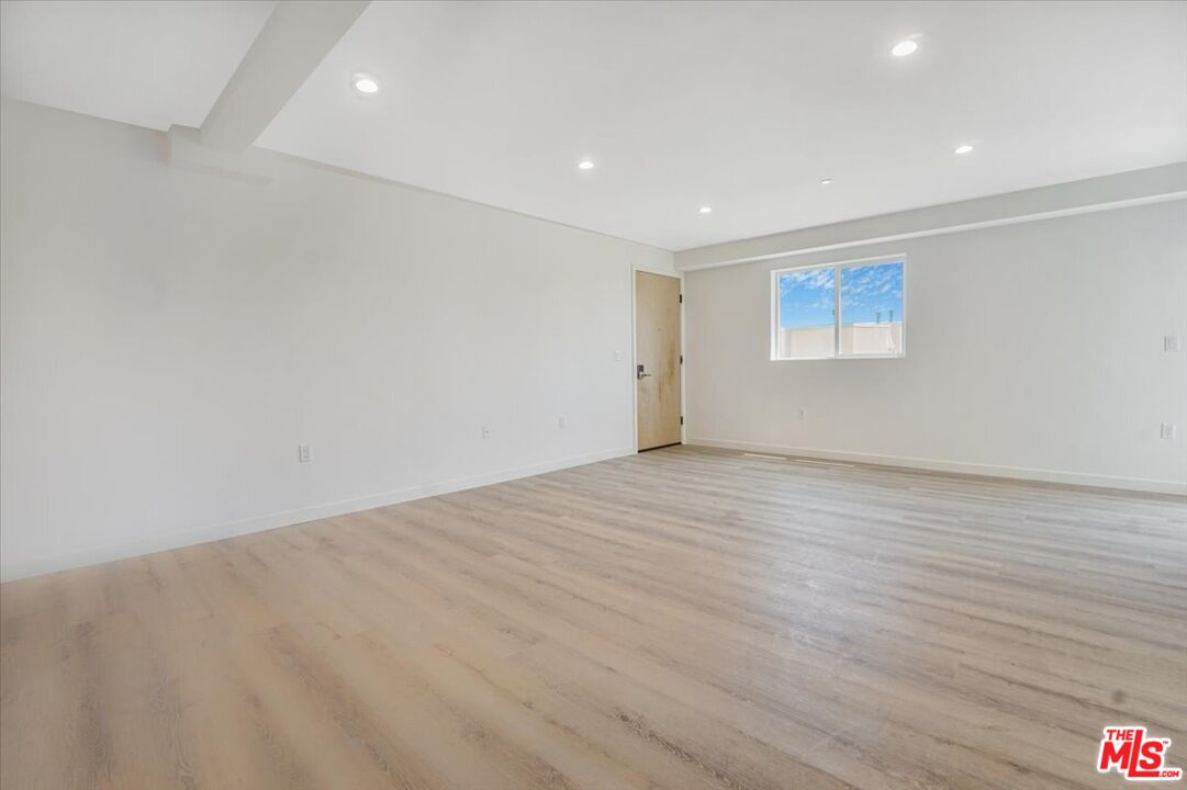 10918 Camarillo Street, Unit 103 North Hollywood, CA 91602 - Photo 37 of 38 an empty room with wooden floor and windows