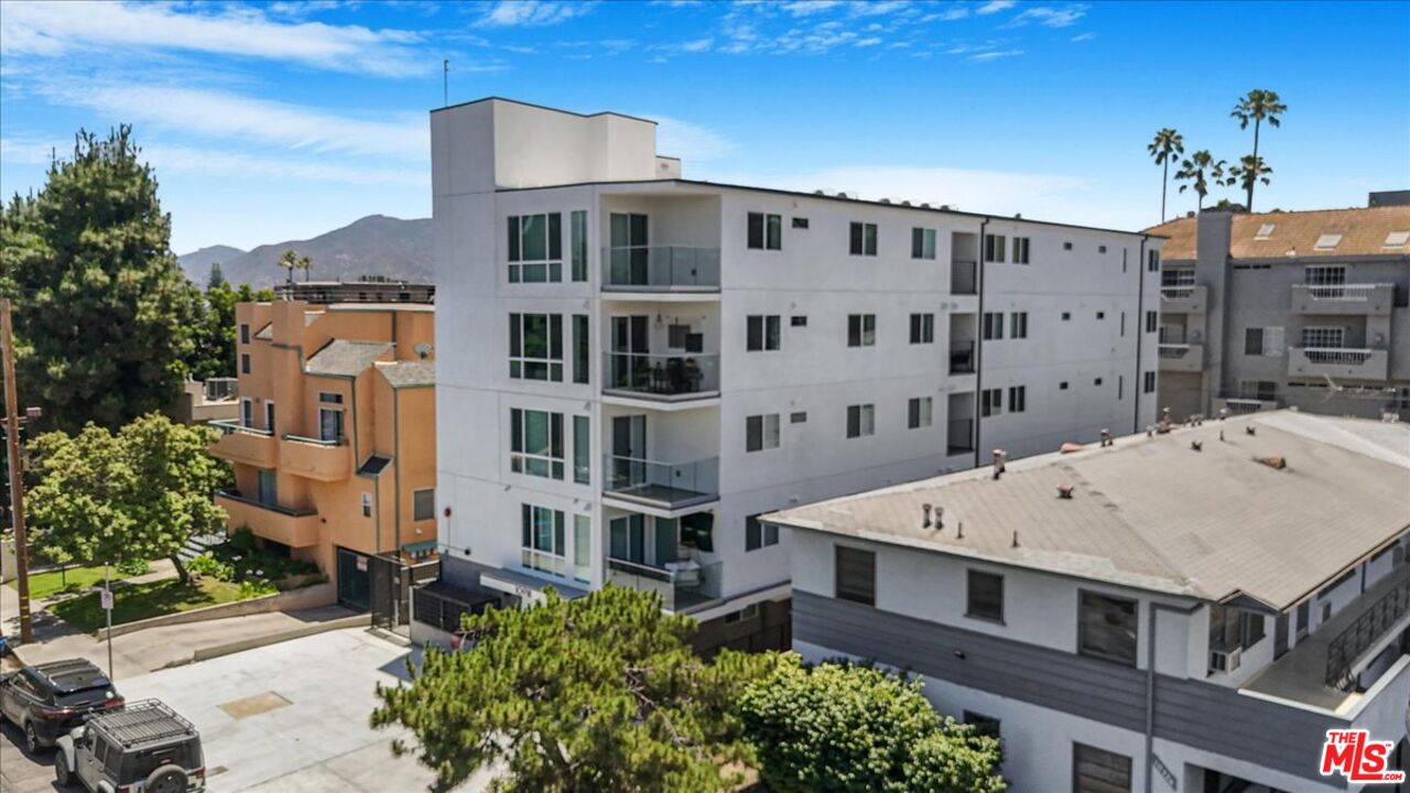 10918 Camarillo Street, Unit 103 North Hollywood, CA 91602 - Photo 4 of 38 a view of a building with a lot of windows and trees