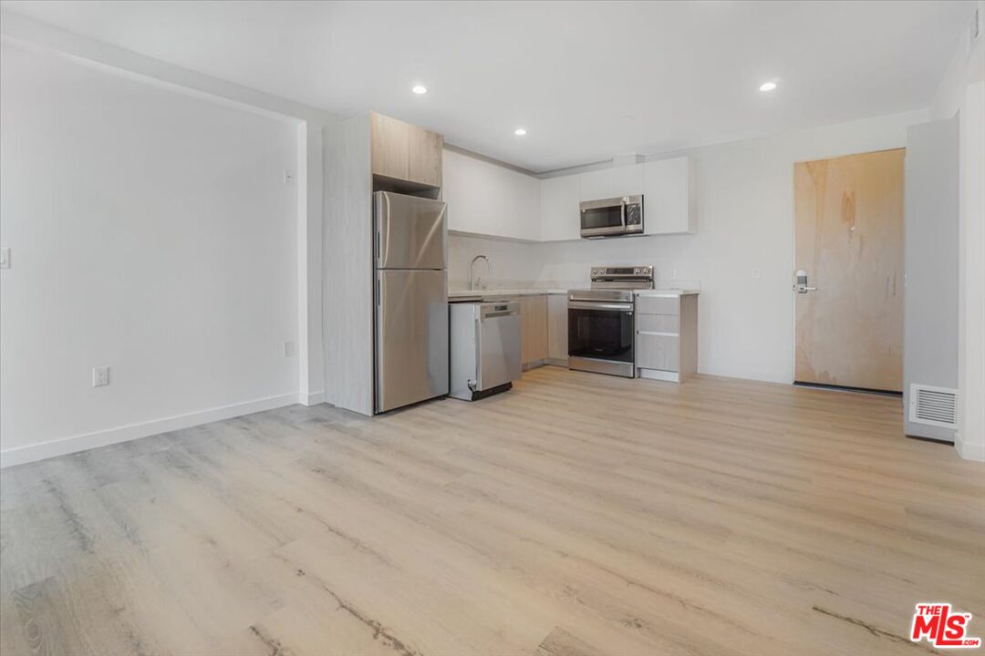 10918 Camarillo Street, Unit 103 North Hollywood, CA 91602 - Photo 6 of 38 a kitchen with stainless steel appliances a refrigerator sink and stove
