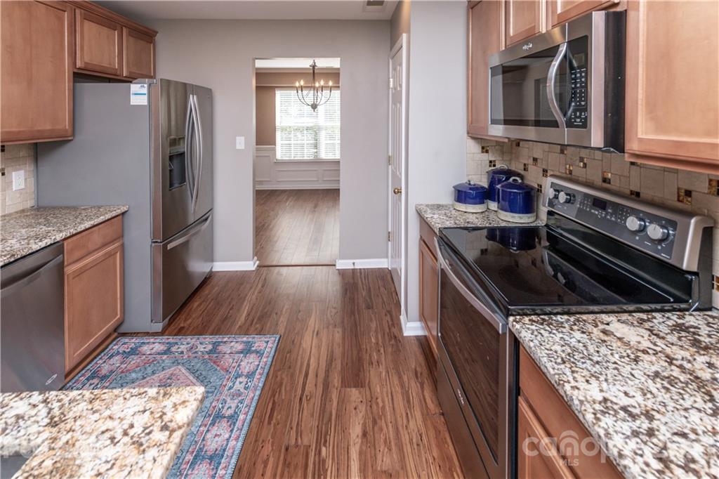1435 Haverford Road Northwest Concord, NC 28027 - Photo 13 of 31 a kitchen with wooden floors and stainless steel appliances