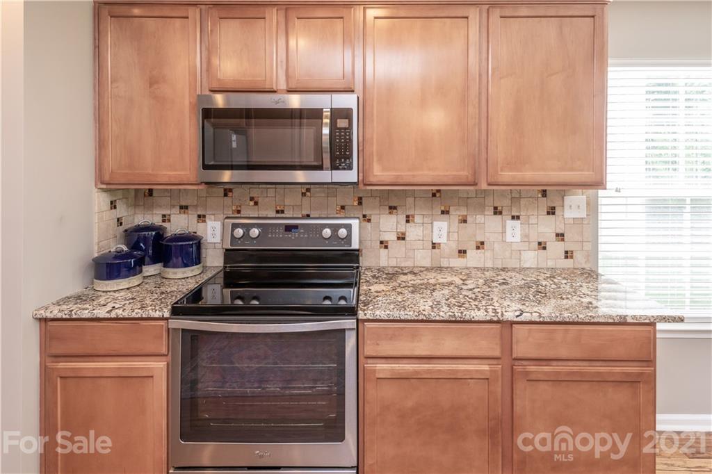 1435 Haverford Road Northwest Concord, NC 28027 - Photo 14 of 31 a kitchen with granite countertop a stove and a microwave