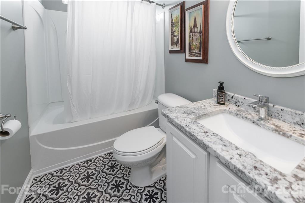 1435 Haverford Road Northwest Concord, NC 28027 - Photo 24 of 31 a bathroom with a granite countertop toilet a sink and a mirror