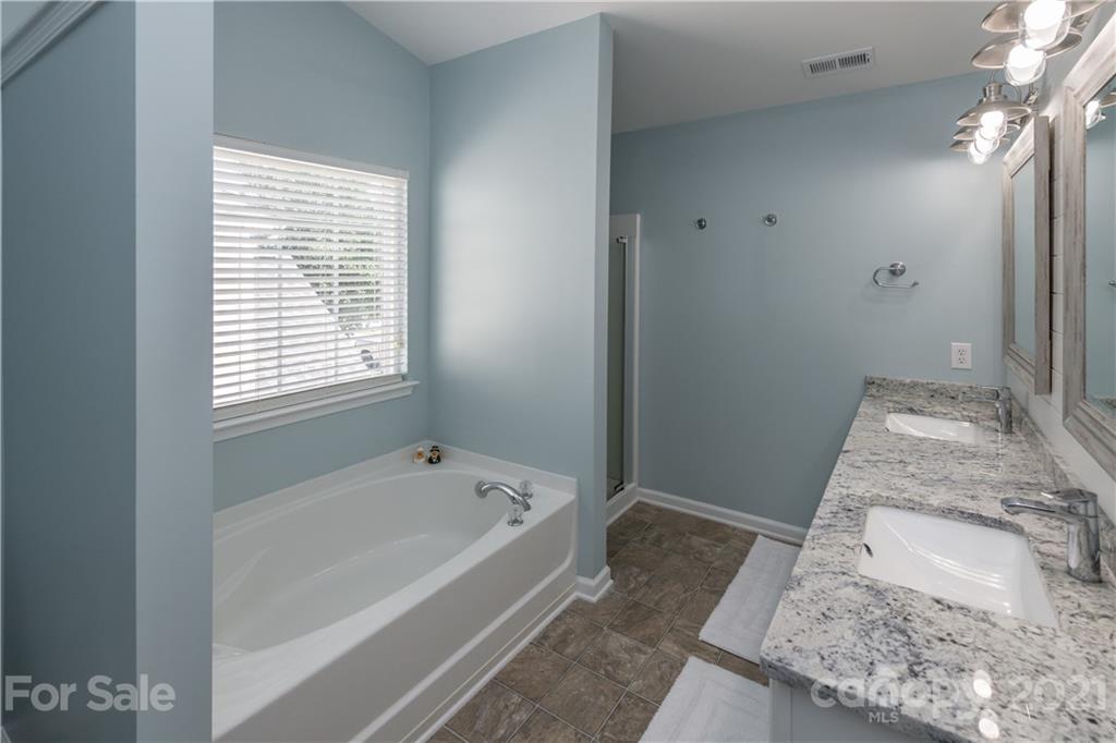 1435 Haverford Road Northwest Concord, NC 28027 - Photo 30 of 31 a bathroom with a granite countertop sink a bathtub and shower