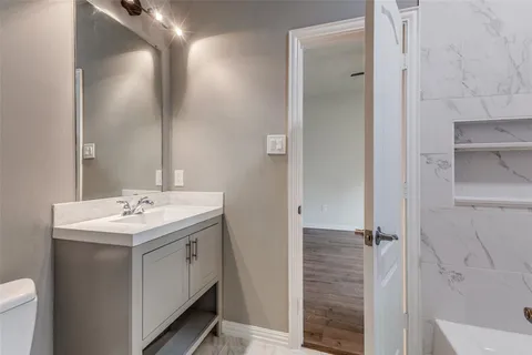 a bathroom with a sink and mirror with toilet