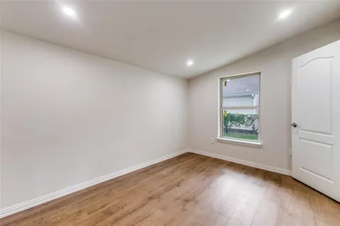 an empty room with wooden floor and window