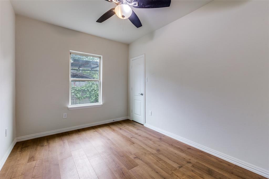 4536 Birch Street Dallas, TX 75223 - Photo 18 of 25 an empty room with wooden floor chandelier fan and windows