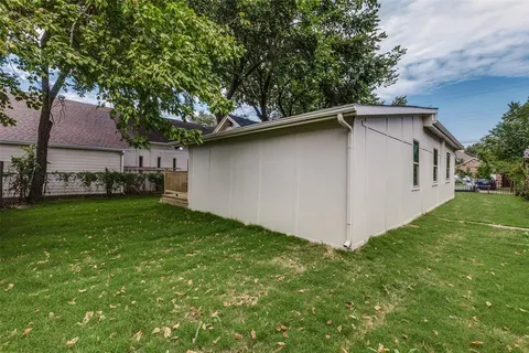 a white house that has tree in front of it