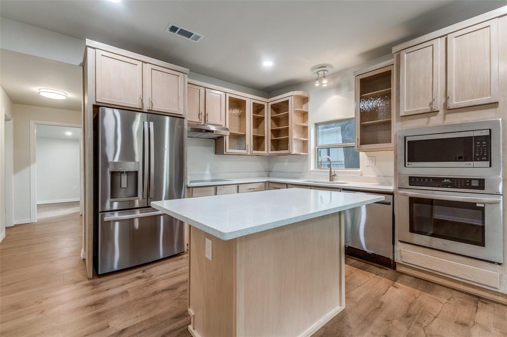 4536 Birch Street Dallas, TX 75223 - Photo 8 of 25 a kitchen with stainless steel appliances granite countertop a refrigerator a stove and a sink with wooden floor