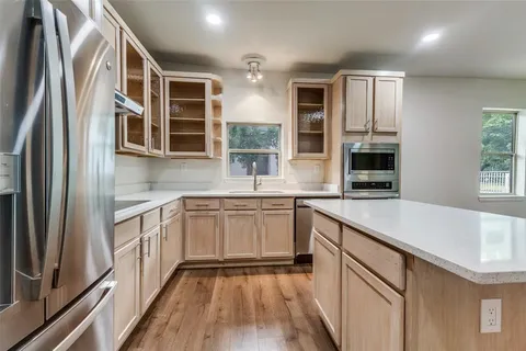 a kitchen with stainless steel appliances granite countertop a refrigerator and a sink