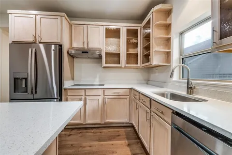 a kitchen with stainless steel appliances granite countertop a sink and a refrigerator
