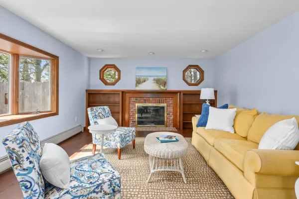 a living room with furniture a clock on wall and a table