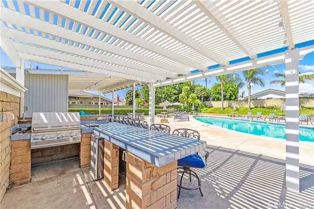 a view of a patio with table and chairs a barbeque with wooden floor and fence
