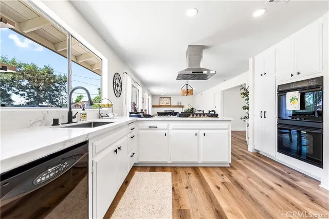 a kitchen with white cabinets and appliances