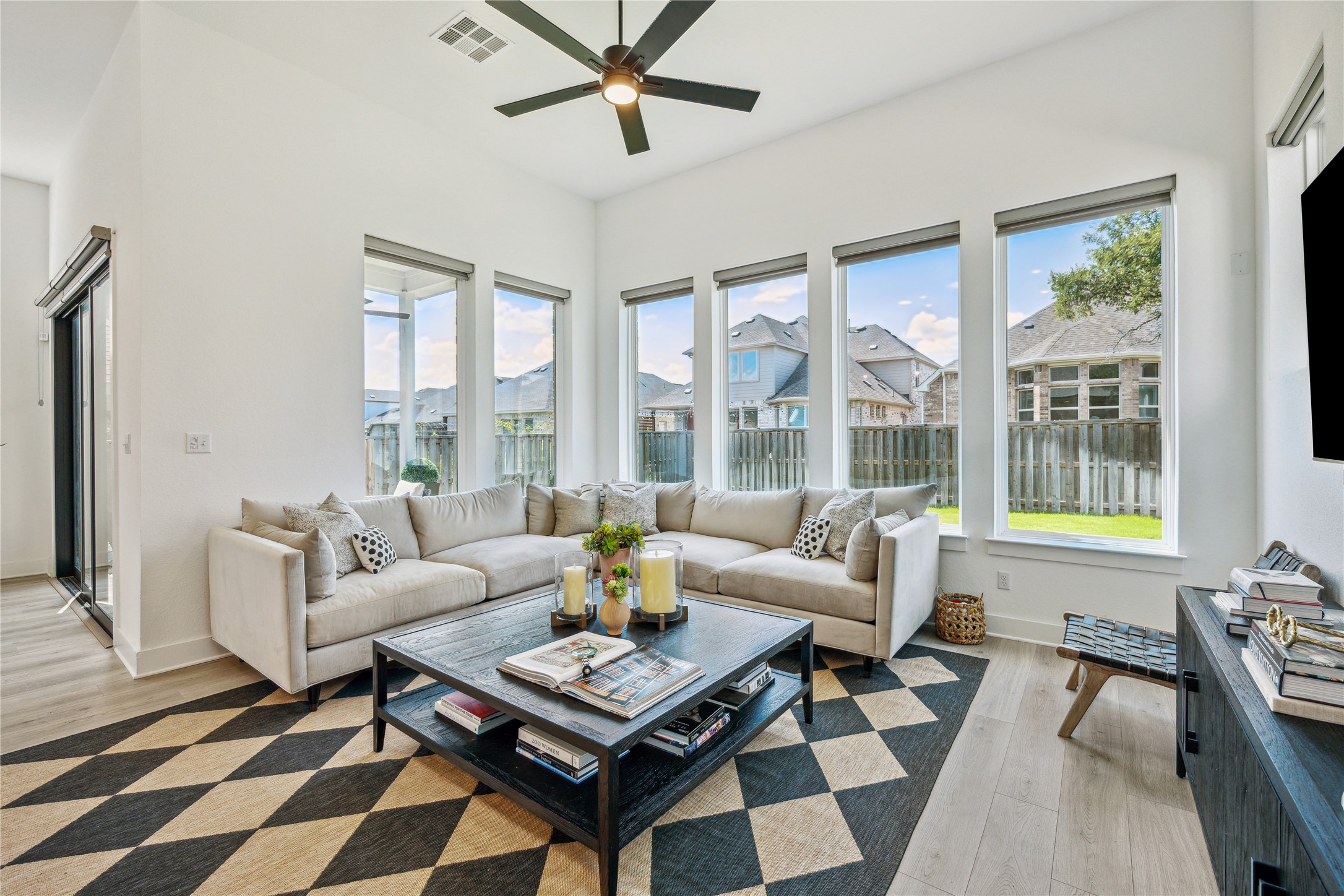 Living area featuring plenty of natural light, ceiling fan, and light wood-style floors