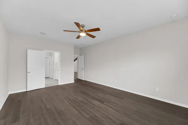 a view of a big room with wooden floor and windows