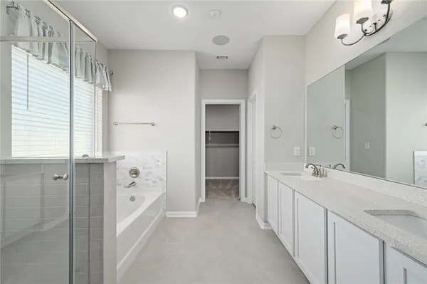 a spacious bathroom with a double vanity sink mirror and shower