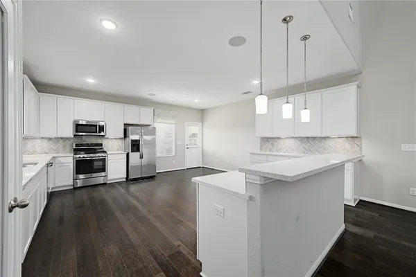 a kitchen with stainless steel appliances granite countertop a sink a stove and a refrigerator