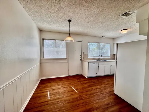 a view of a kitchen with wooden floor and a kitchen