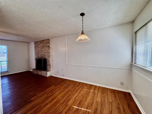 a view of empty room with wooden floor and window