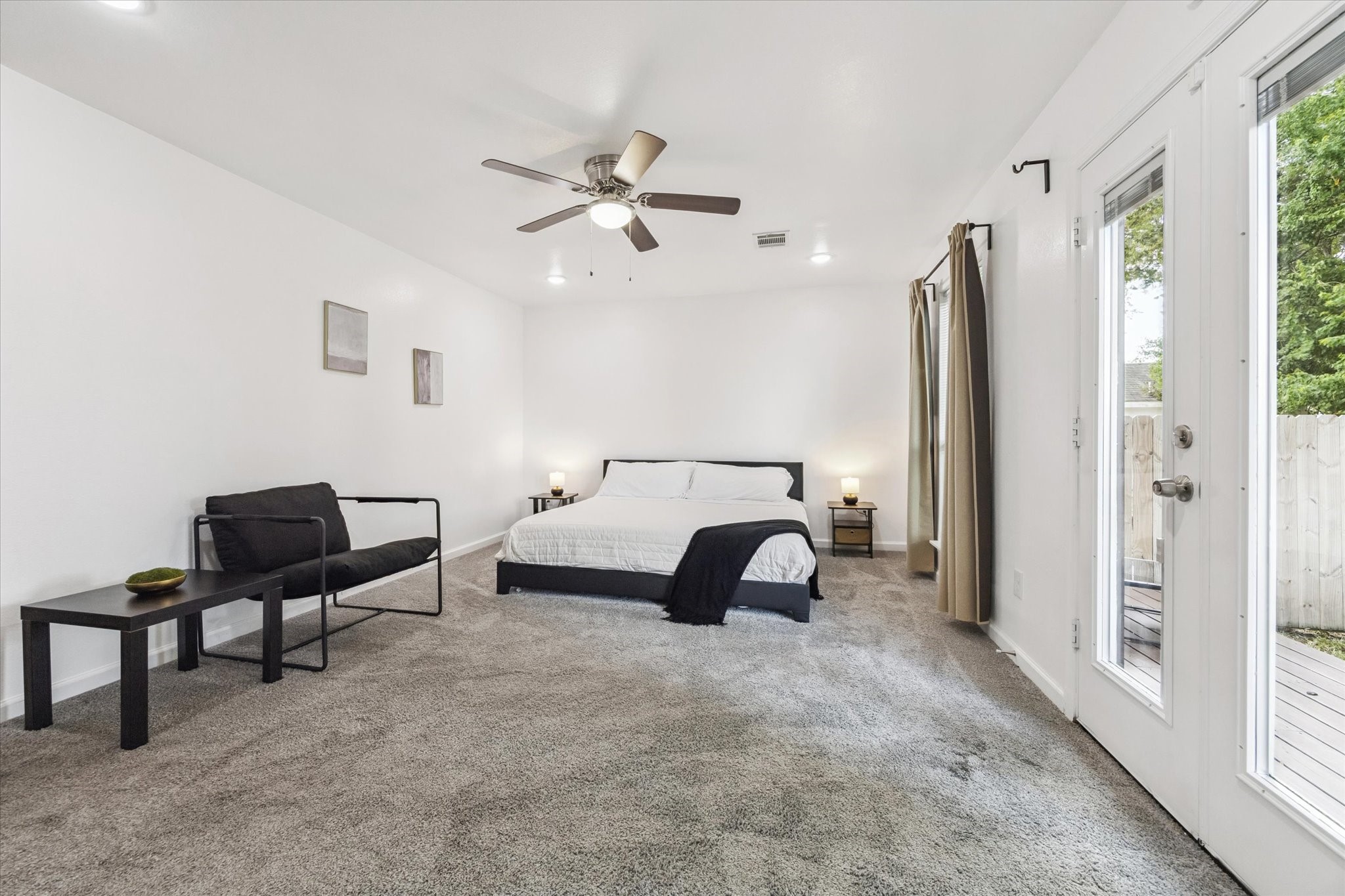 2631 Stevens Street Houston, TX 77026 - Photo 15 of 25 The primary bedroom is generously sized with plenty of room to stretch out. It features recessed lighting, a ceiling fan with light kit, and direct access to a large outdoor deck—ideal for morning coffee or winding down in the evening.