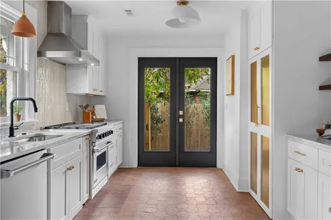 a kitchen with stainless steel appliances granite countertop a stove a sink and a refrigerator with wooden floor