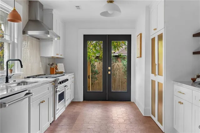 a kitchen with stainless steel appliances granite countertop a stove a sink and a refrigerator with wooden floor