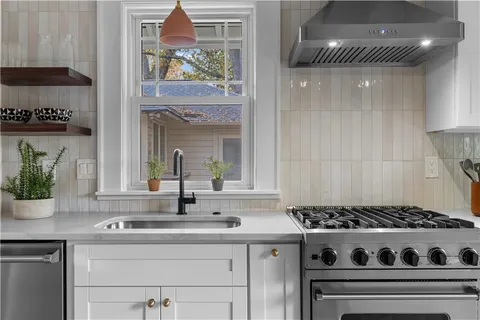 a kitchen with a stove and a white cabinets