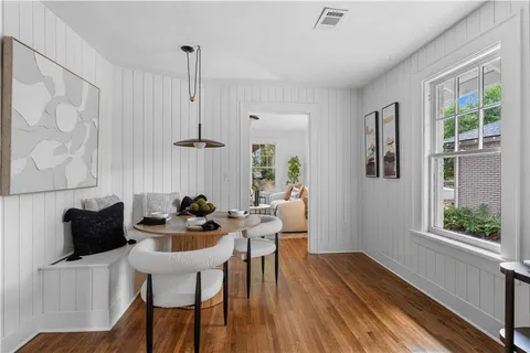 a dining room with furniture a chandelier and wooden floor