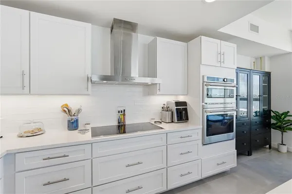 a kitchen with white cabinets and refrigerator