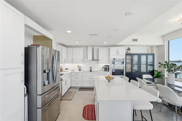 a kitchen with refrigerator and chairs