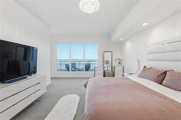 a bedroom with a bed and large windows