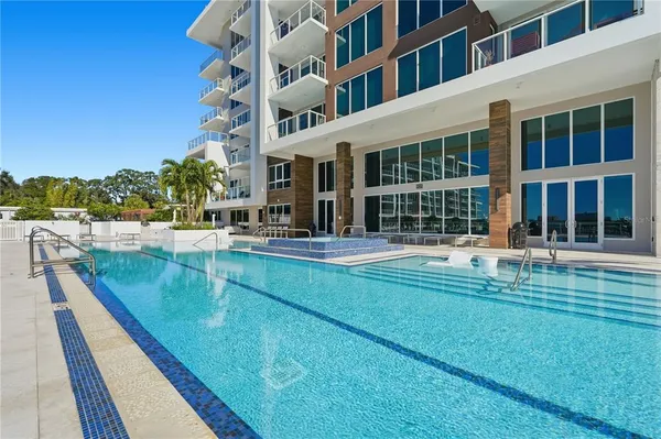 a view of a patio with couches table and chairs with wooden floor and fence