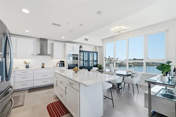a kitchen with white cabinets and chairs