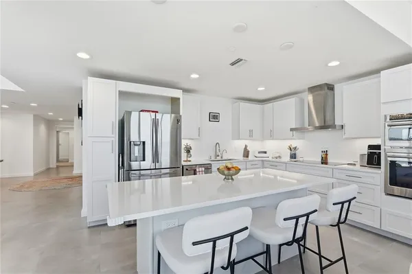 a kitchen with a sink cabinets and chairs