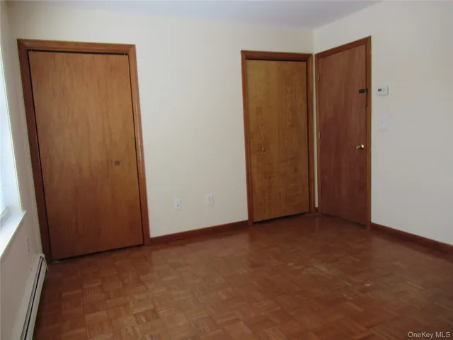 an empty room with wooden floor and a window