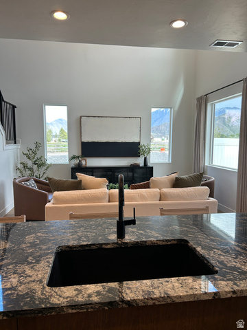 2011 West 1150 South, Unit 1042 Payson, UT 84651 - Photo 19 of 39 Photos are of model home.Kitchen island with a dark granite-style countertop, featuring an undermount sink and a matte black faucet