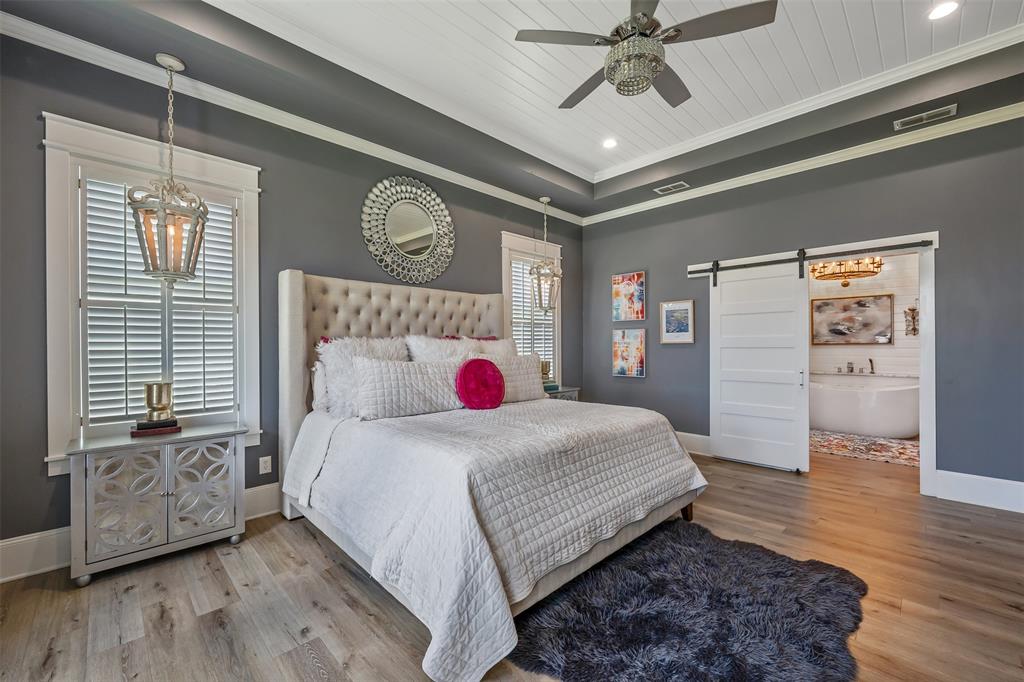 16241 Big Oak Bay Road Tyler, TX 75707 - Photo 18 of 40 Spacious bedroom featuring wood-finish flooring, a tray ceiling with shiplap detailing, and a modern ceiling fan