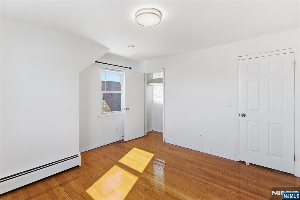 71 Mitchell Street, Unit 2 Lodi, NJ 07644 - Photo 15 of 16 an empty room with wooden floor and windows